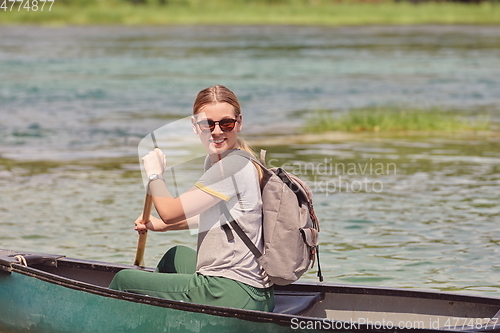 Image of woman adventurous explorer are canoeing in a wild river