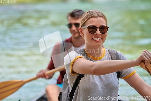 Image of friends are canoeing in a wild river