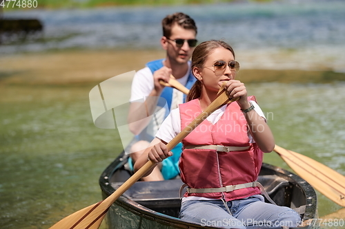 Image of friends are canoeing in a wild river