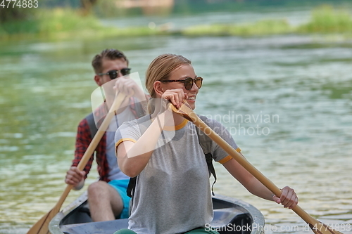 Image of friends are canoeing in a wild river