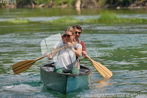 Image of friends are canoeing in a wild river