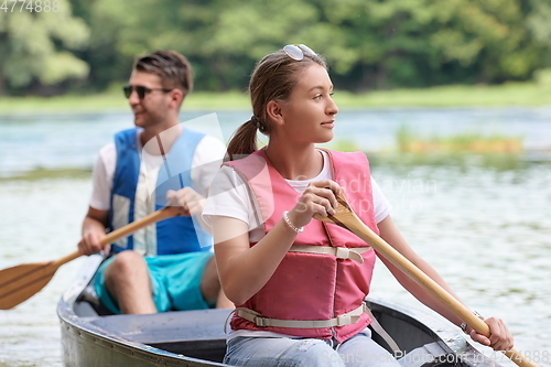 Image of friends are canoeing in a wild river