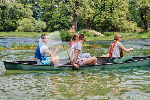 Image of Group adventurous explorer friends are canoeing in a wild river