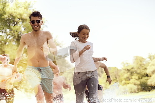 Image of group of happy friends having fun on river