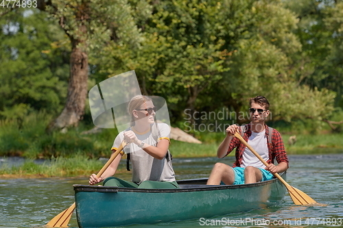 Image of friends are canoeing in a wild river