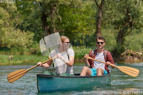 Image of friends are canoeing in a wild river