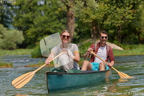 Image of friends are canoeing in a wild river