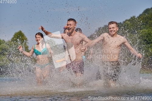 Image of group of happy friends having fun on river
