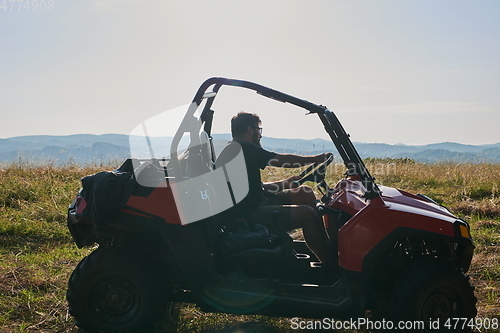 Image of man enjoying beautiful sunny day while driving a off road buggy car