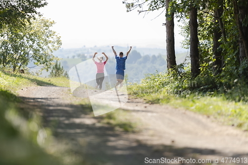 Image of couple enjoying in a healthy lifestyle while jogging on a country road