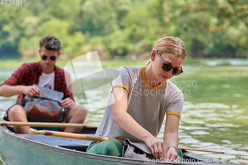 Image of friends are canoeing in a wild river