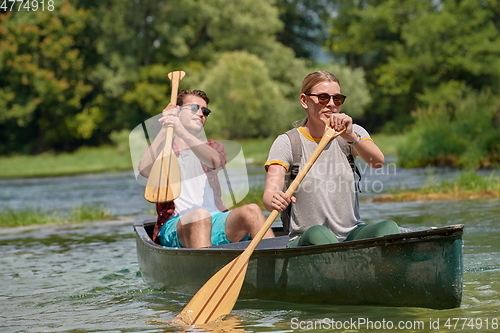 Image of friends are canoeing in a wild river