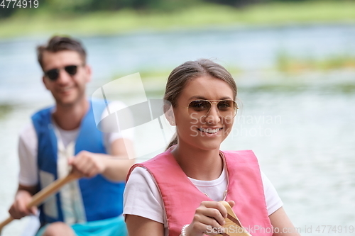 Image of friends are canoeing in a wild river