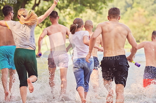 Image of group of happy friends having fun on river