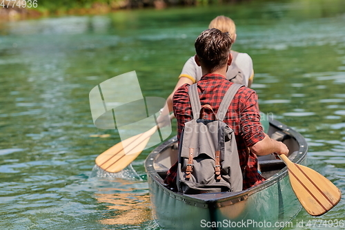 Image of friends are canoeing in a wild river