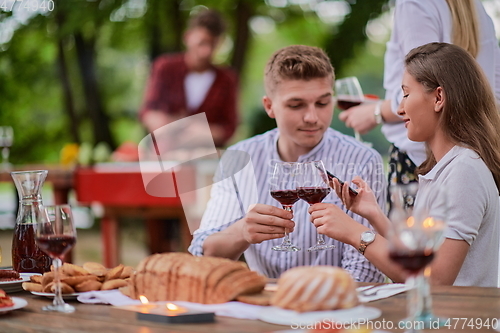 Image of friends having picnic french dinner party outdoor during summer holiday