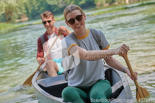 Image of friends are canoeing in a wild river