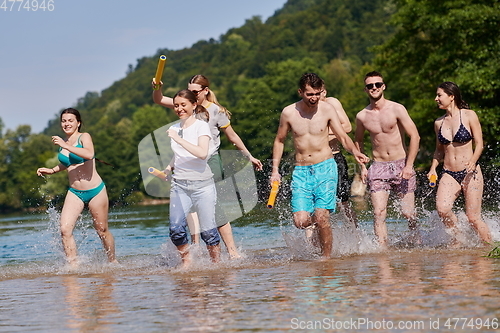 Image of group of happy friends having fun on river