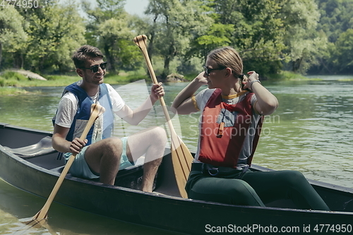 Image of friends are canoeing in a wild river