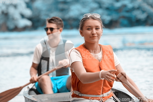 Image of friends are canoeing in a wild river