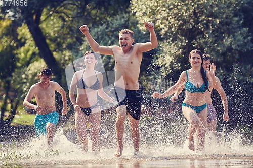 Image of group of happy friends having fun on river