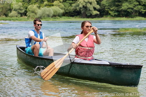 Image of friends are canoeing in a wild river