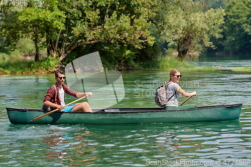 Image of friends are canoeing in a wild river