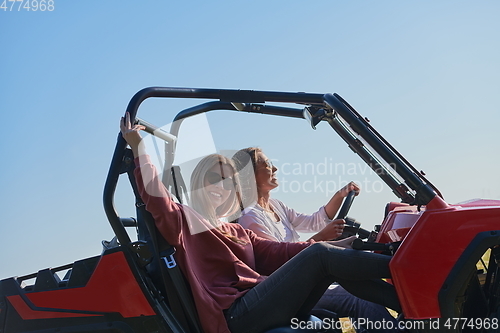 Image of girls enjoying a beautiful sunny day while driving an off-road car