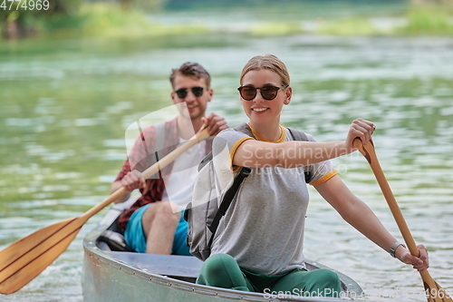 Image of friends are canoeing in a wild river