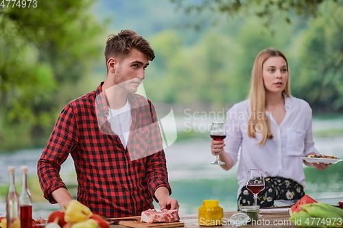 Image of friends having picnic french dinner party outdoor during summer holiday