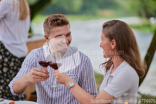 Image of friends having picnic french dinner party outdoor during summer holiday