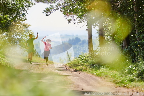 Image of couple enjoying in a healthy lifestyle while jogging on a country road