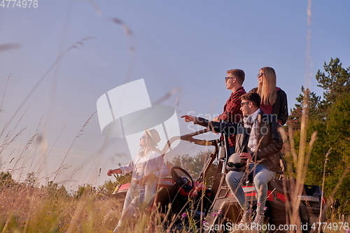 Image of group young people resting after driving a off road buggy car