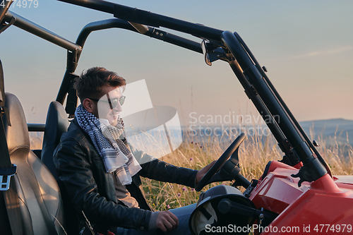 Image of man enjoying beautiful sunny day while driving a off road buggy car