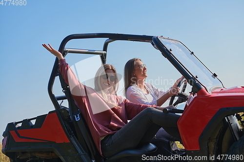 Image of girls enjoying a beautiful sunny day while driving an off-road car