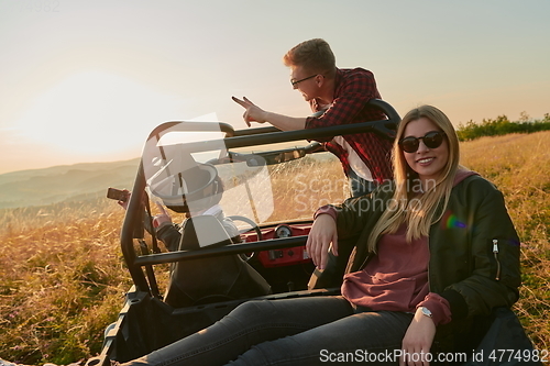 Image of group young happy people enjoying beautiful sunny day while driving a off road buggy car