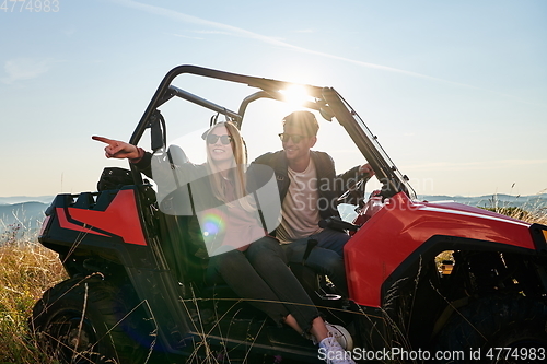 Image of couple enjoying beautiful sunny day while driving a off road buggy