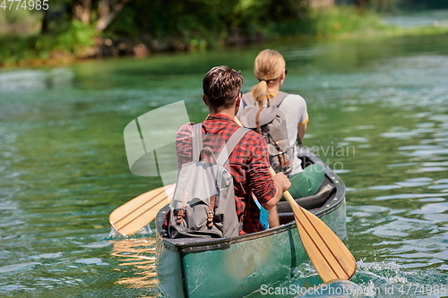 Image of friends are canoeing in a wild river