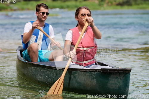 Image of friends are canoeing in a wild river