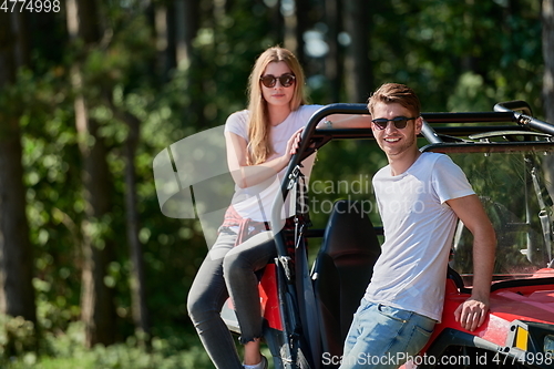 Image of couple enjoying beautiful sunny day while driving a off road buggy