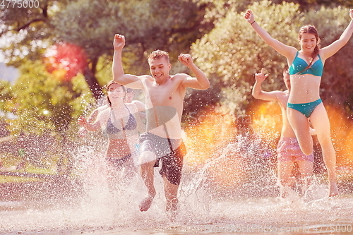 Image of group of happy friends having fun on river