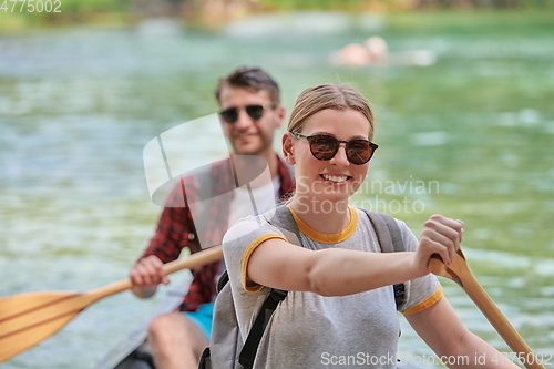 Image of friends are canoeing in a wild river