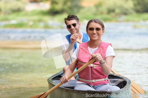 Image of friends are canoeing in a wild river