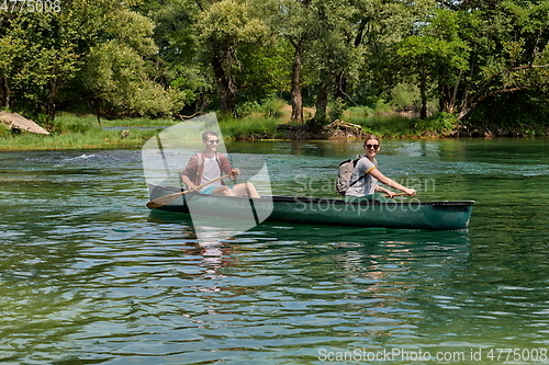 Image of friends are canoeing in a wild river