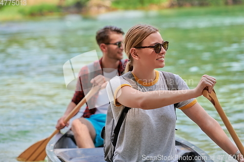 Image of friends are canoeing in a wild river