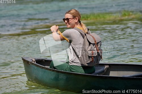 Image of woman adventurous explorer are canoeing in a wild river