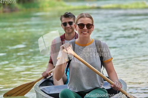 Image of friends are canoeing in a wild river