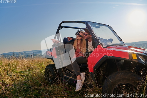 Image of couple enjoying beautiful sunny day while driving a off road buggy