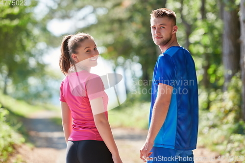 Image of couple enjoying in a healthy lifestyle while jogging on a country road