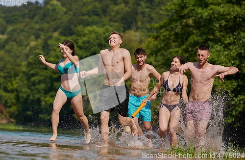 Image of group of happy friends having fun on river